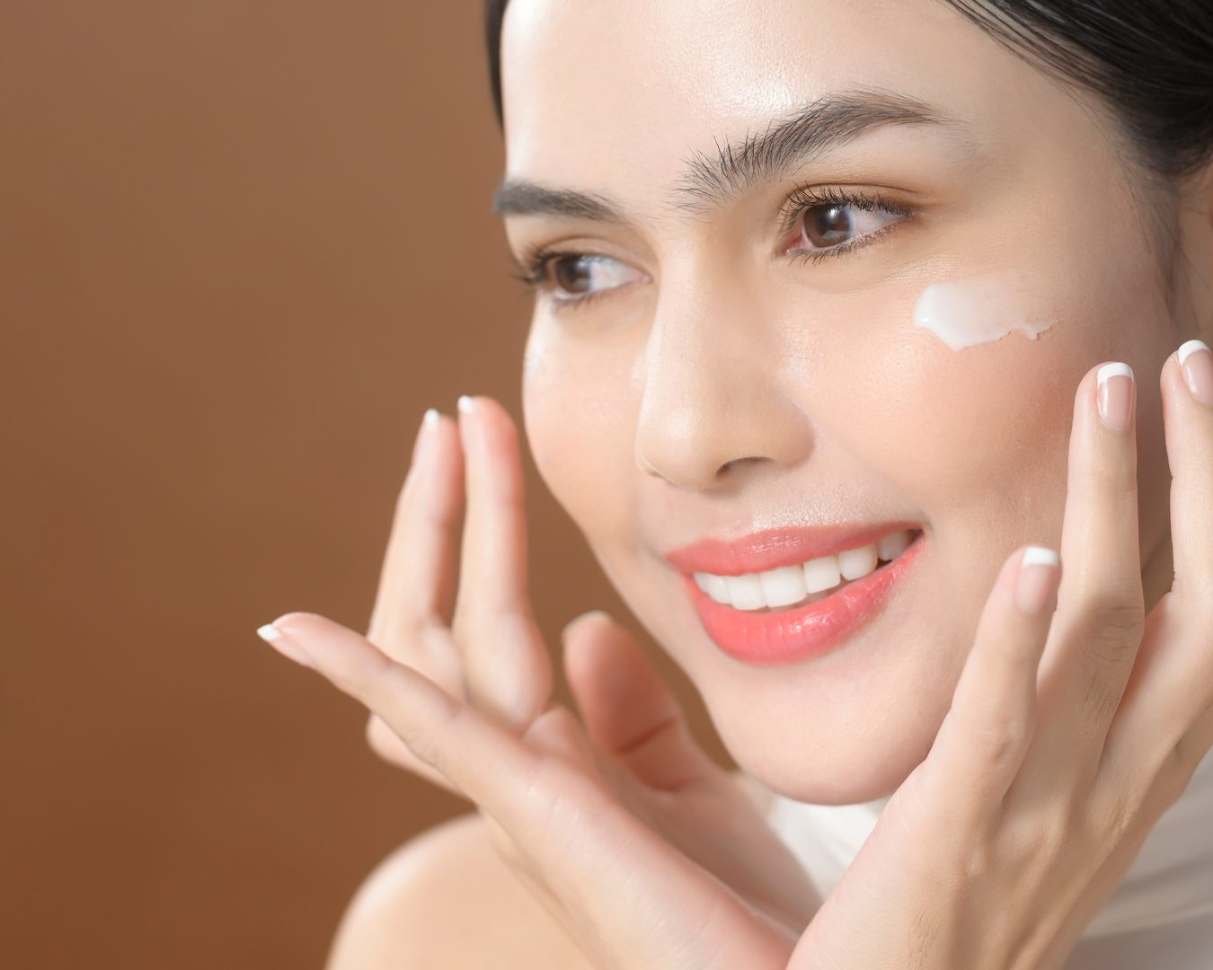 A young woman with beautiful face is holding cream , using cream of her face , beauty skin care concept
